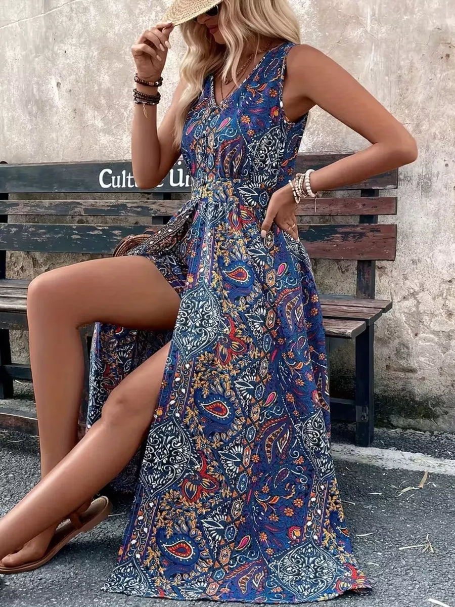 Vibrant paisley print maxi romper in multicolor with V-neck, cinched waist, and dramatic leg slit.