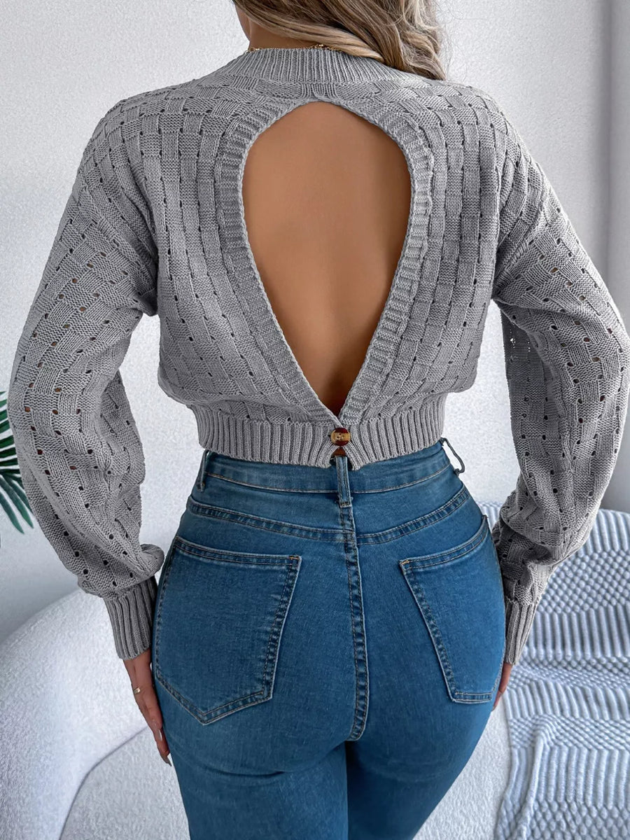 Gray backless openwork knit sweater with basketweave detail and button closure.