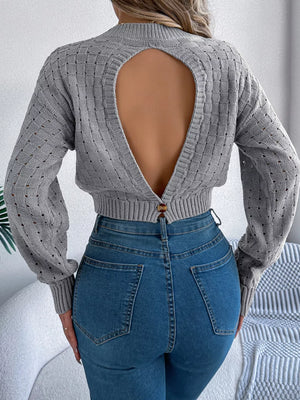 Gray backless openwork knit sweater with basketweave detail and button closure.