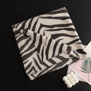 Zebra stripe wool scarf in khaki and black with fringed edges.