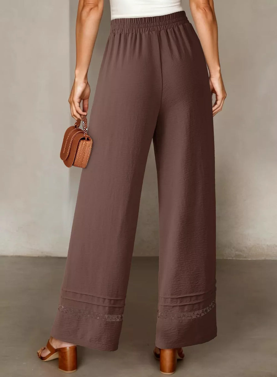 Brown relaxed wide-leg maternity trousers with drawstring waist and lace trim hem detail.