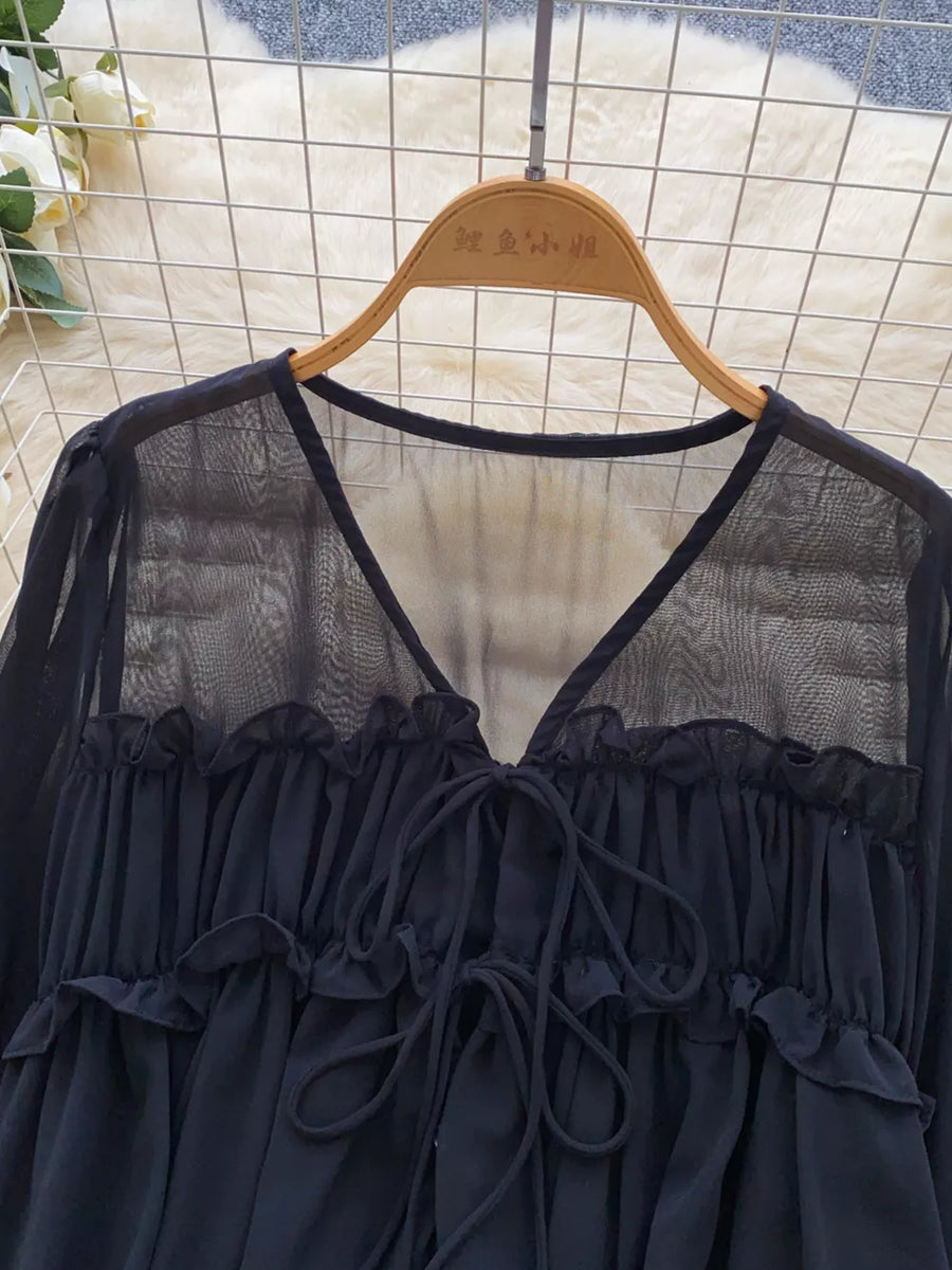 Black chiffon blouse with V-neck, tie front, and ruffled details.