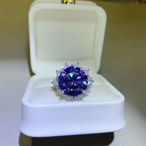 Dark blue moissanite cocktail ring in sterling silver with a halo of smaller stones.