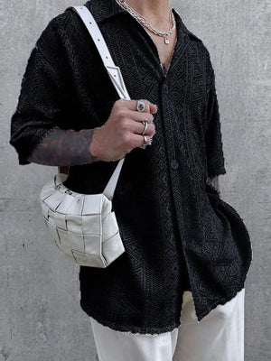 Black geometric crochet resort shirt with button-up front and short sleeves.