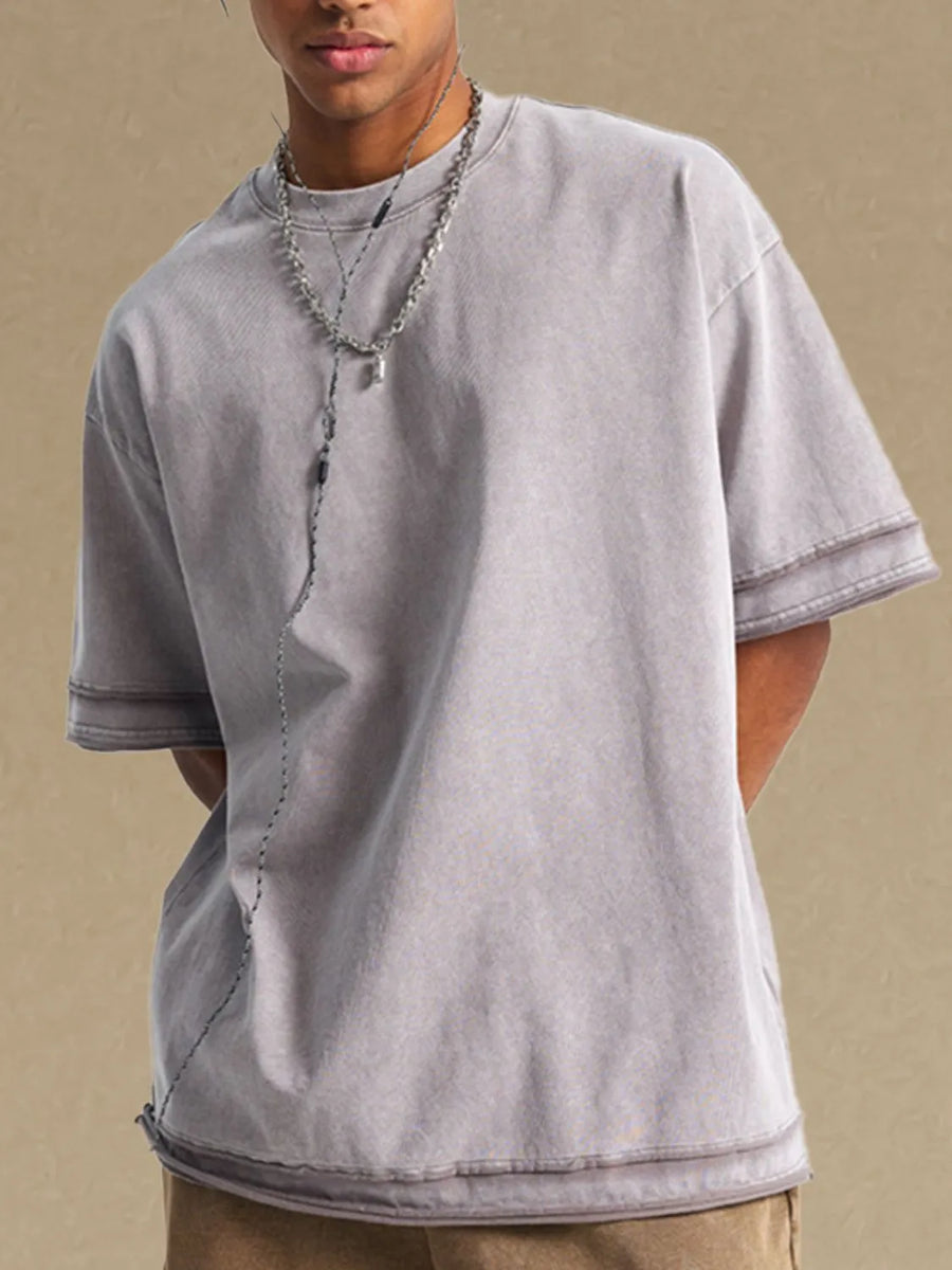 Gray washed cotton t-shirt with raw edges and double-stitched sleeves.