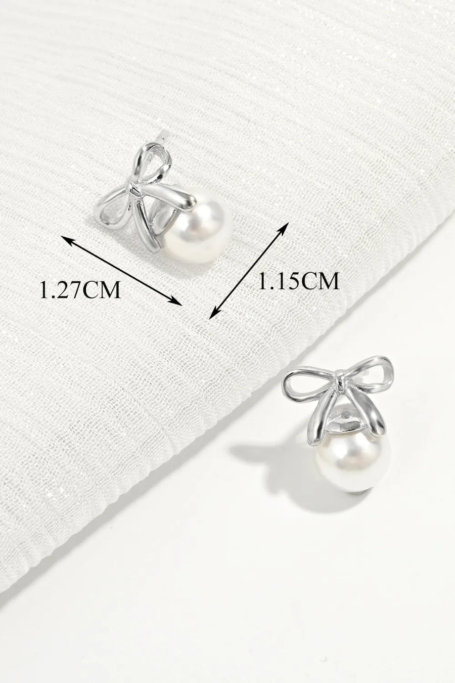 Silver bow pearl drop earrings with detailed measurements shown.