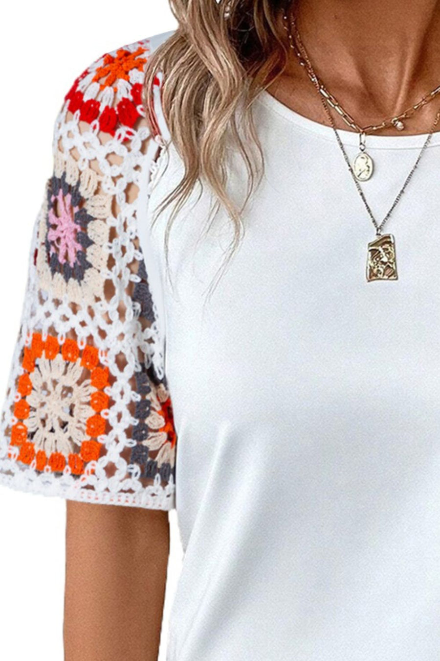 White t-shirt with colorful granny square crochet sleeves.