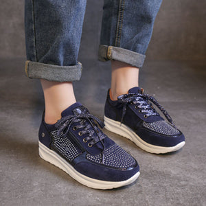 Blue lace-up sneakers with rhinestone embellishments and a chunky sole.