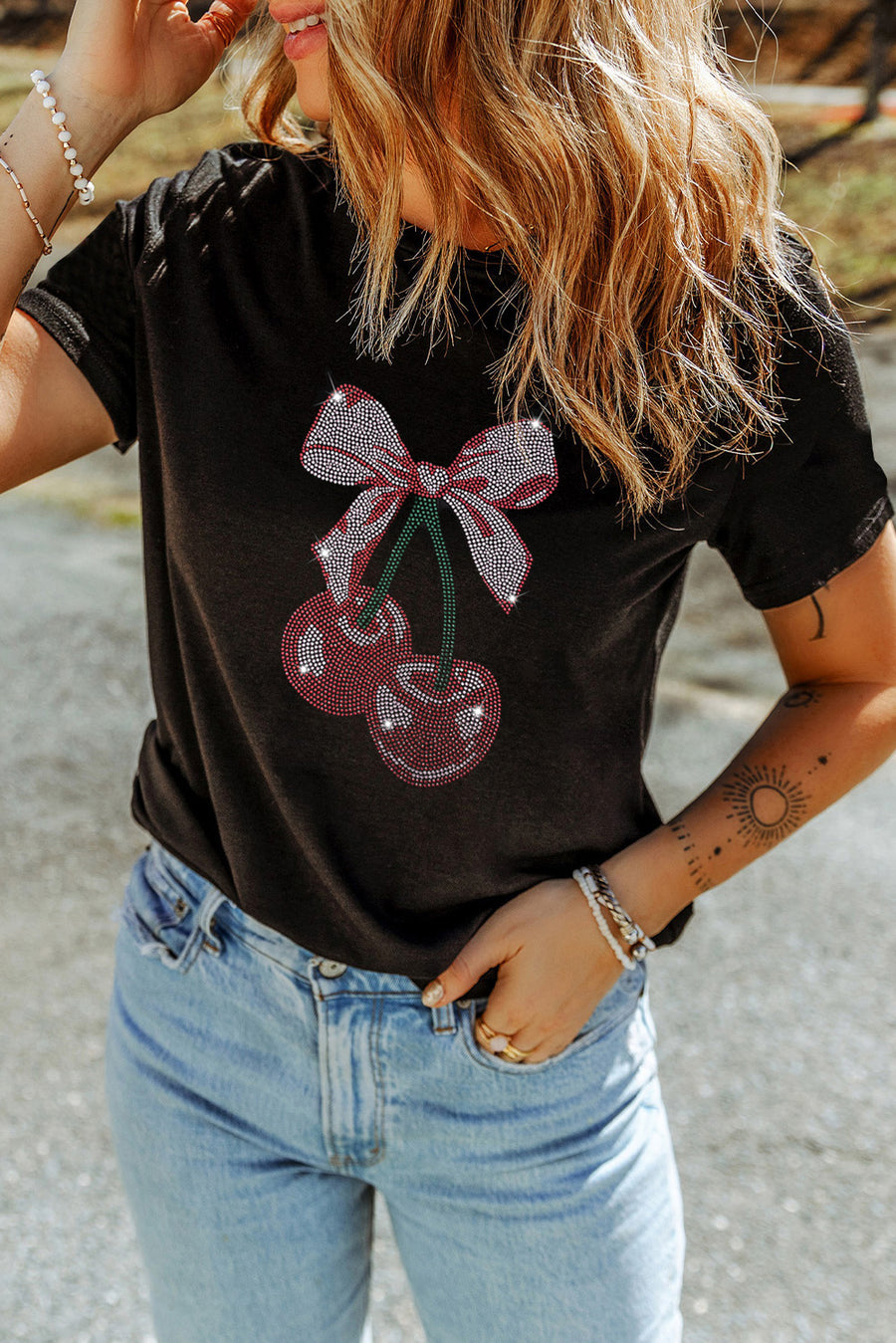 Black t-shirt with rhinestone cherry bow graphic.
