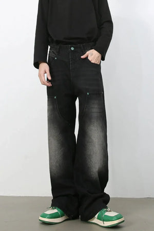 Faded wash wide-leg carpenter jeans in dark black with green button detail.