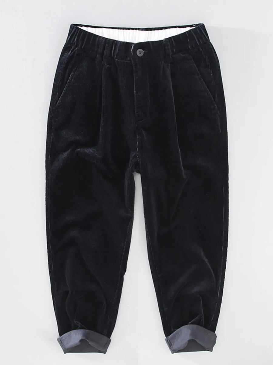 Black corduroy pleated pants with elastic waistband and cuffed hem