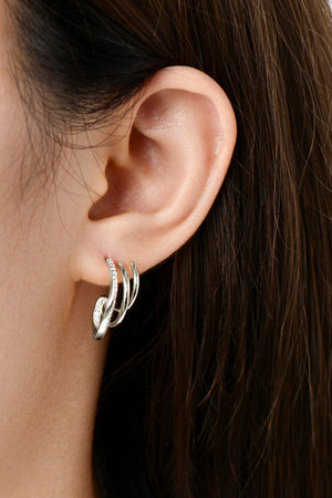 Silver triple hoop diamond stud earrings with a curved design.
