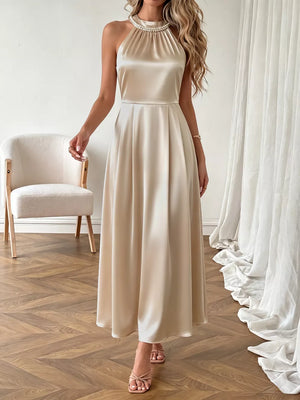 Champagne satin midi dress with pearl halter neckline and a-line skirt.