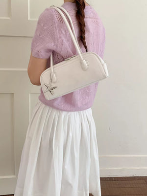 White shoulder bag with star charm and double straps.