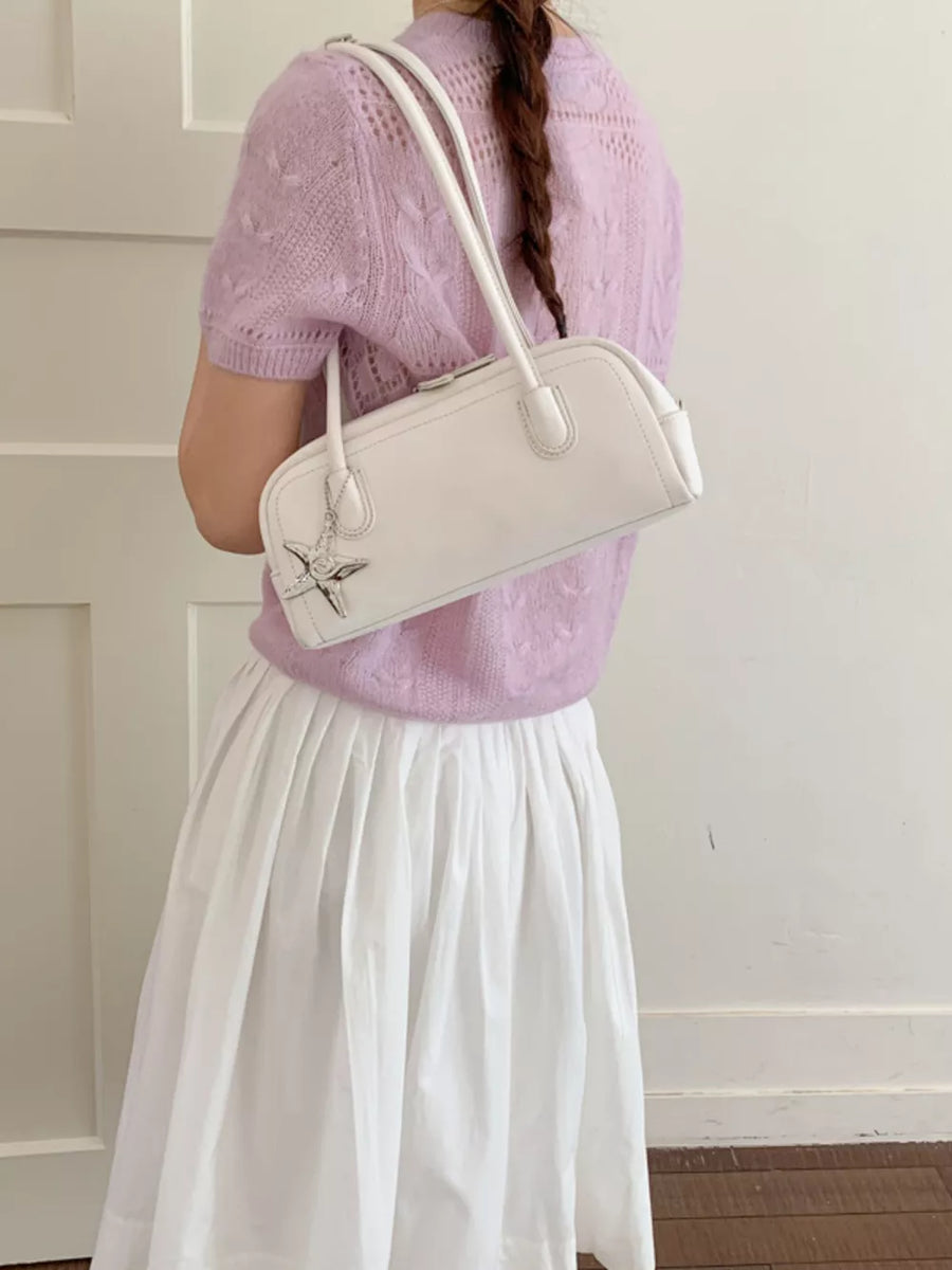 White shoulder bag with star charm and double straps.