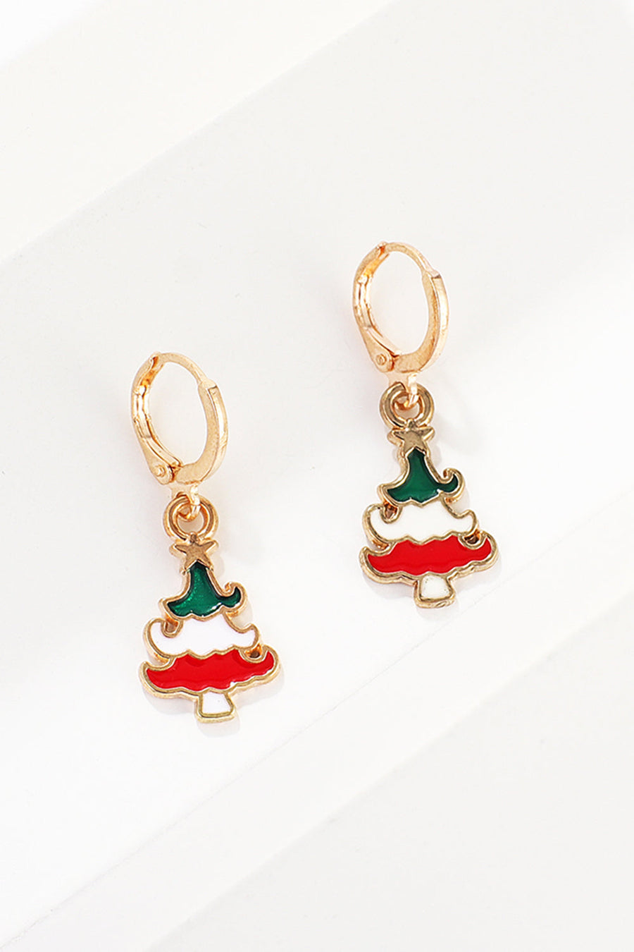 Festive Christmas tree hoop earrings with red, white, and green enamel detail.