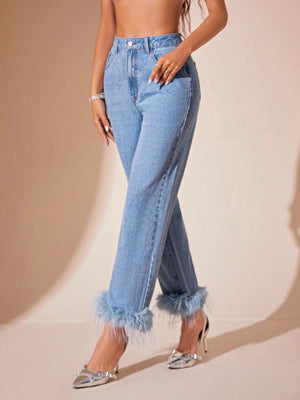 Light wash denim jeans with feather trim at the cuffs.