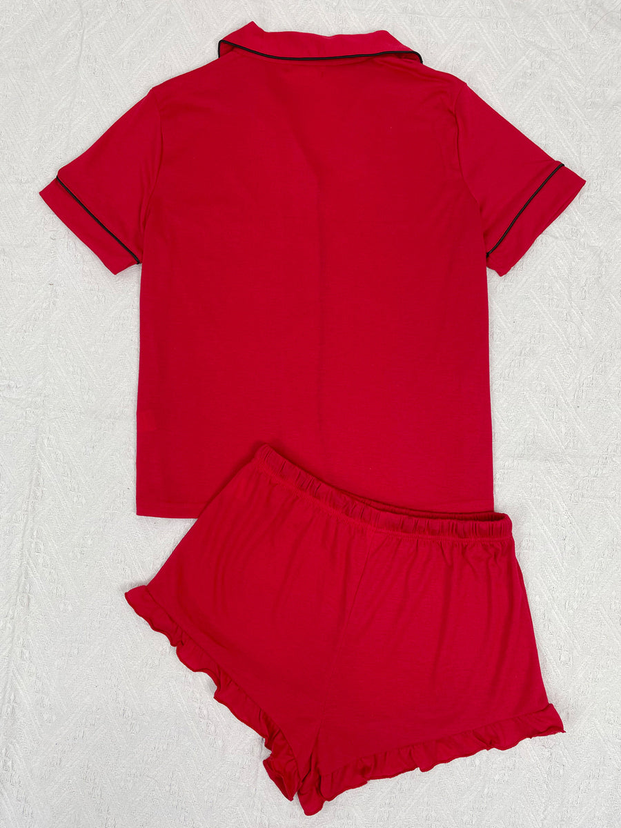 Red short sleeve pajama set with black trim and ruffled shorts