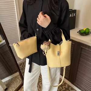 crossbody bag in pale yellow featuring adjustable strap and bucket fit