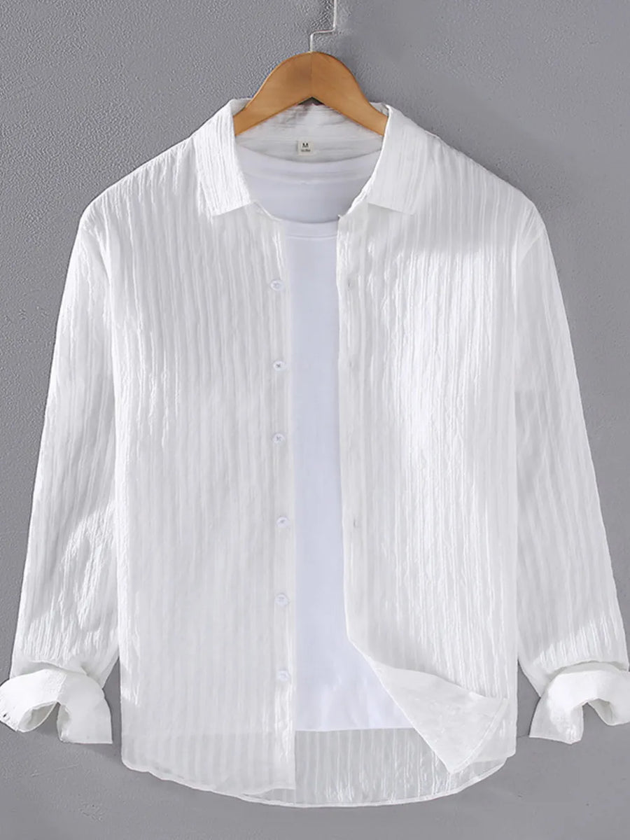 White textured long sleeve button-up overshirt with classic collar, worn over a white tee.