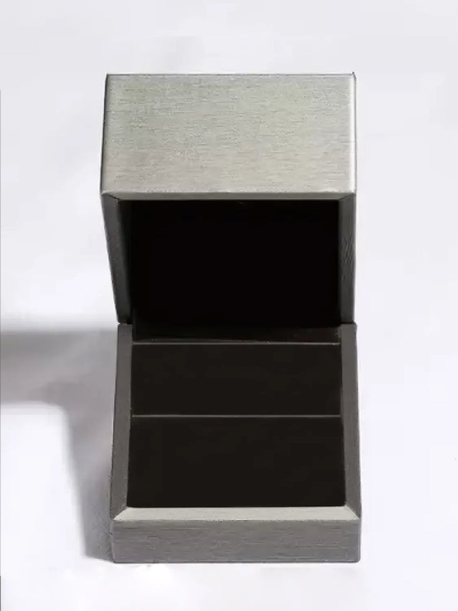 Silver ring box with open lid and dark interior