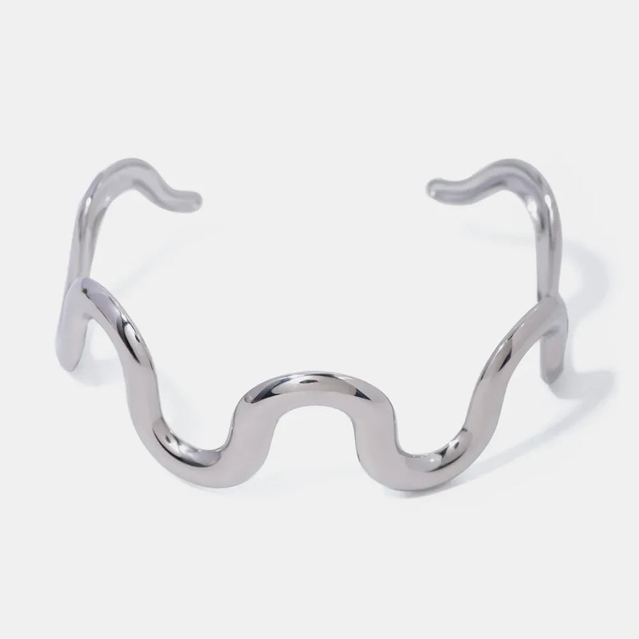 Sculptural ripple cuff bracelet in silver with a wavy, artistic design.