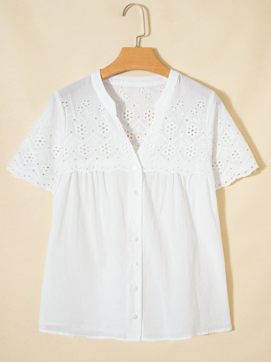 White cotton eyelet embroidered sheer shirt with short sleeves and button front.
