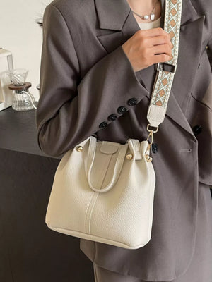 Textured crossbody bag in Rice White with a unique patterned strap and gold hardware.