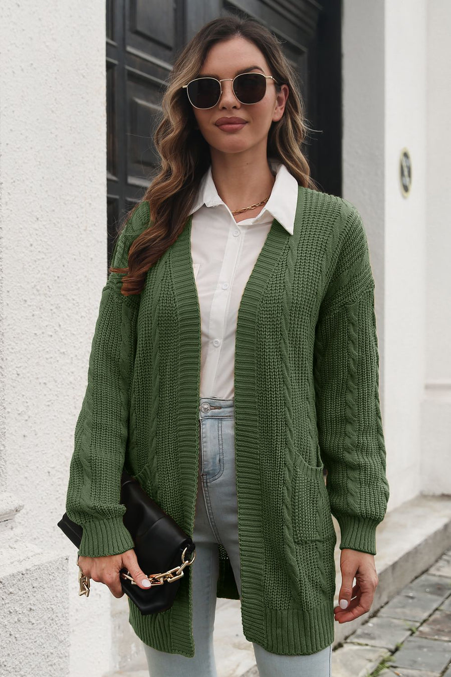 Army green cable knit longline cardigan with pockets, open front, and long sleeves.