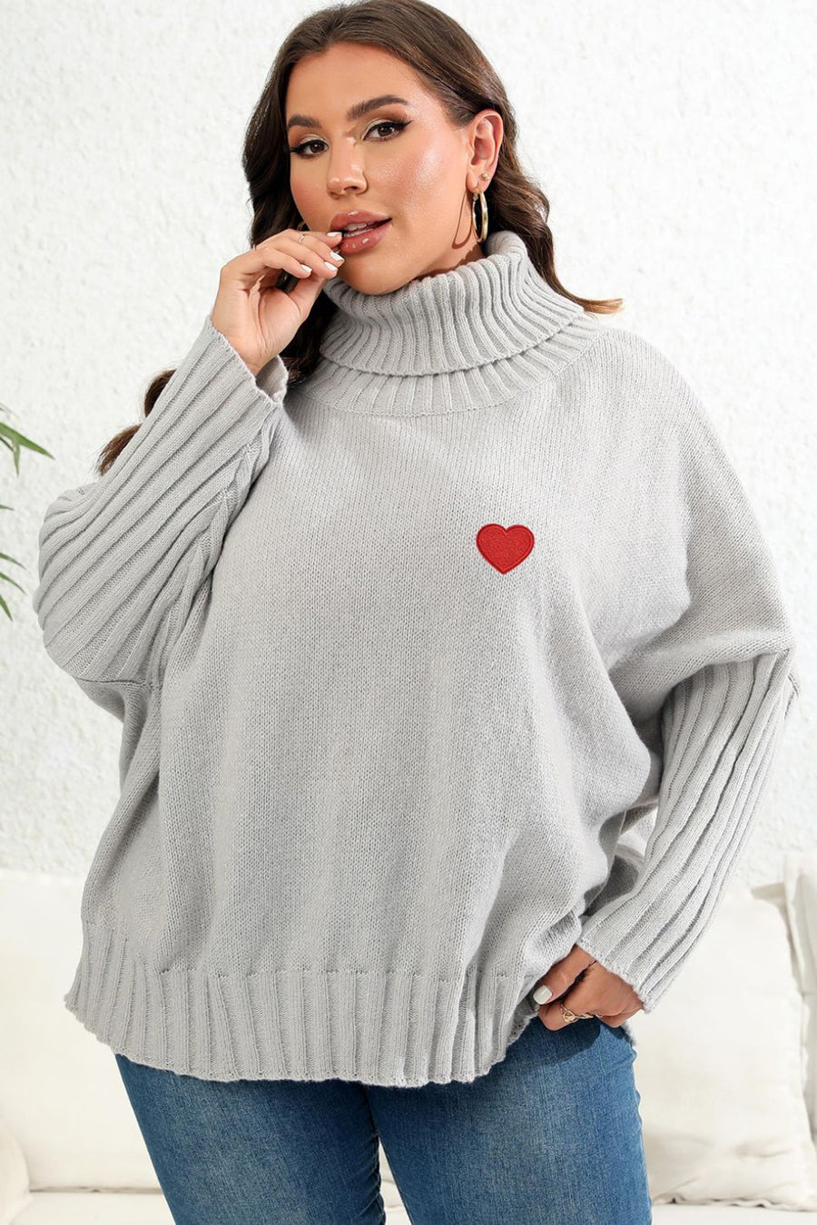 Light Gray knit turtleneck sweater with batwing sleeves and a red heart appliqué.