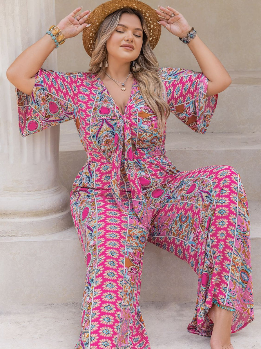 Bohemian tie-front palazzo jumpsuit in pink with bell sleeves and a vibrant paisley print.