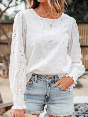 White cotton blouse with eyelet embroidery, ruffled cuffs, and smocked sleeves.