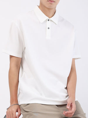 White textured short sleeve polo shirt with button placket and classic collar.