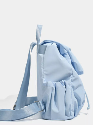 Blue nylon drawstring backpack with flap closure and cinched pockets.