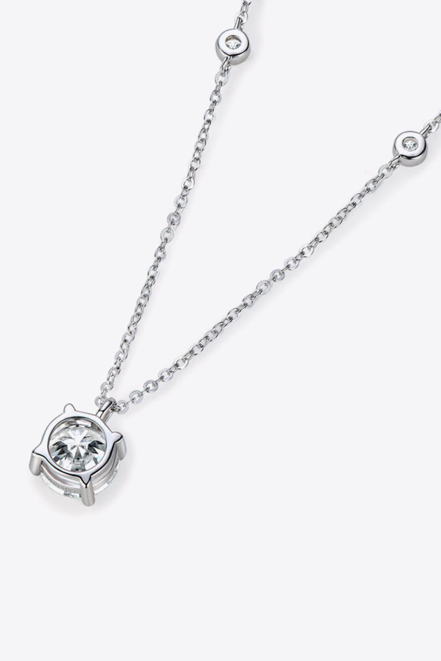 Silver moissanite solitaire necklace with a delicate chain and bezel-set stones.