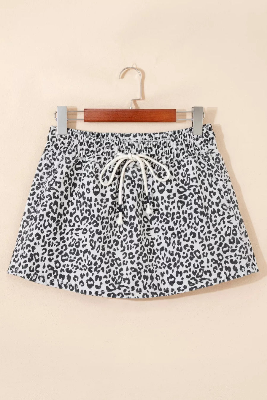 Leopard print denim skort in black and white with drawstring waist and pockets.