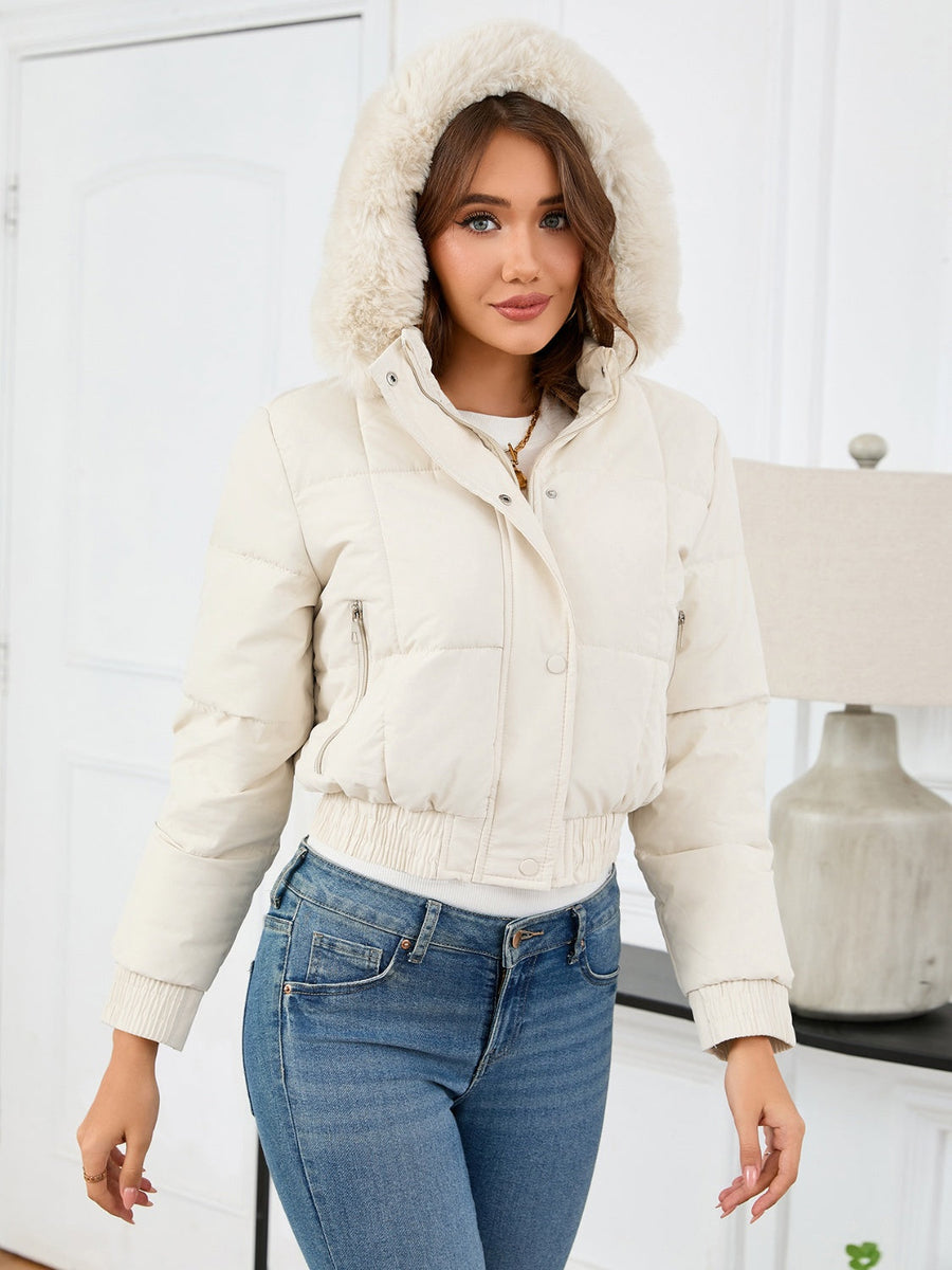 Cream puffer jacket with faux fur trim hood, cinched waist, and zip pockets.