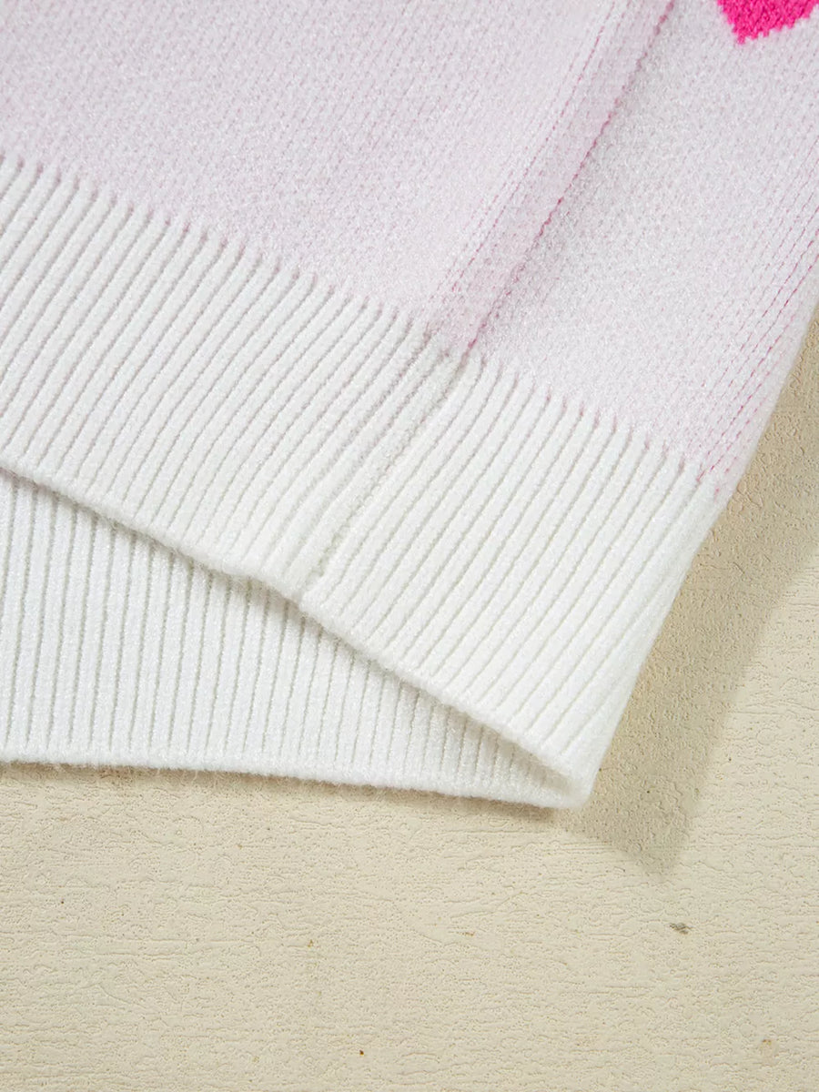 Pink and white knit sweater with heart pattern detail and ribbed trim.
