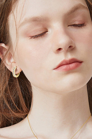 Gold moissanite channel-set hoop earrings with sparkling stones.
