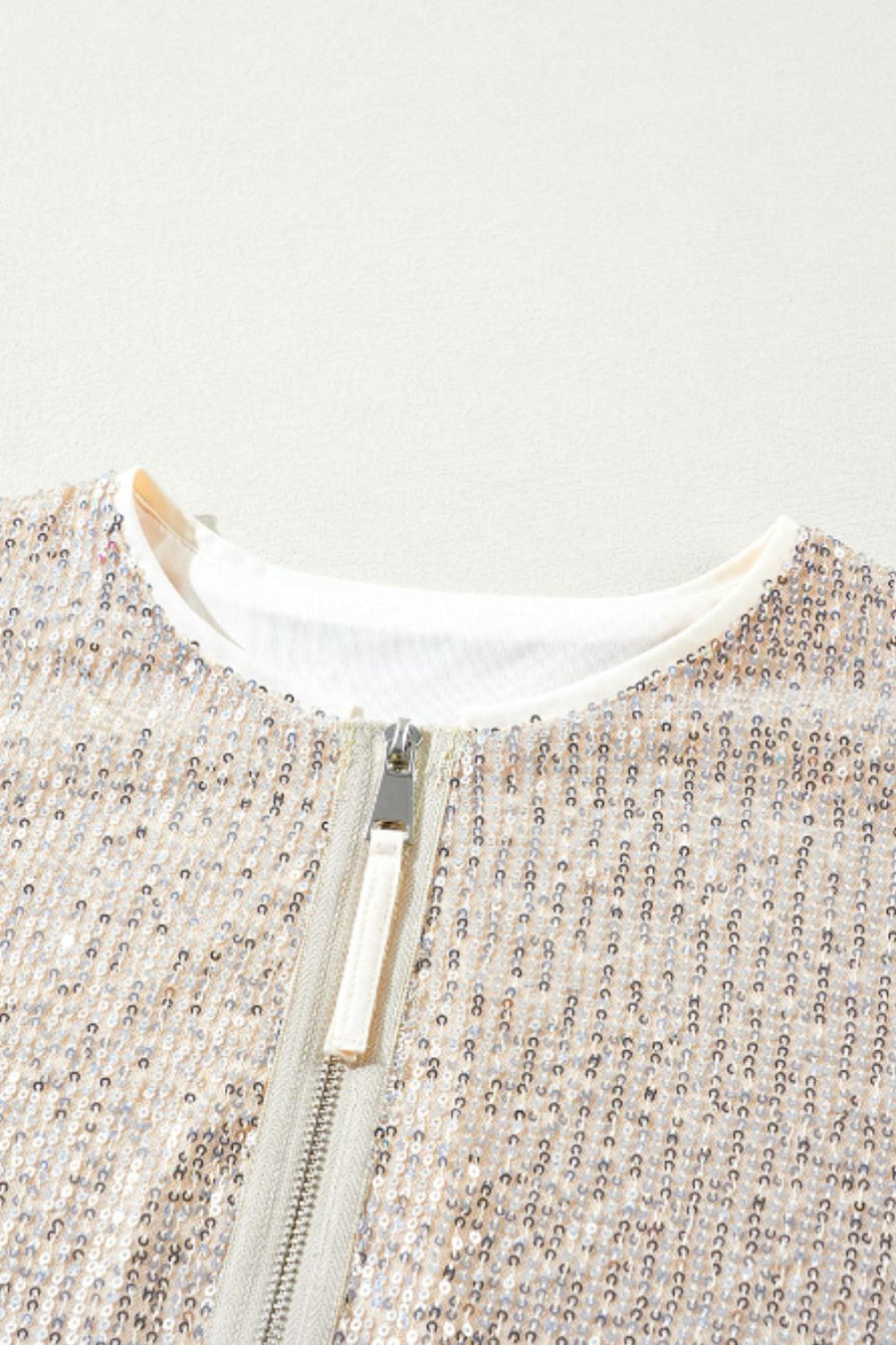 Sequin bomber jacket in cream with ribbed trim and silver zipper detail.