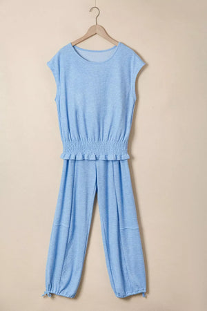 Light blue knit cap sleeve top with smocked waist and jogger pants with drawstring ankles.