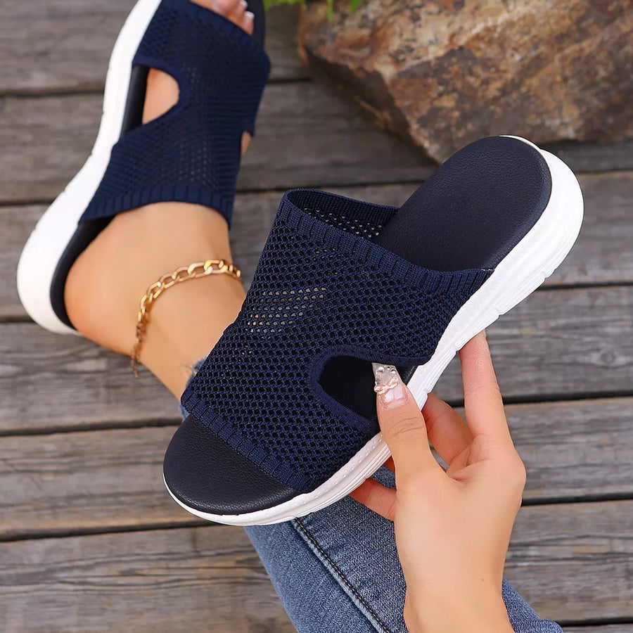 Dark blue mesh open-toe sandals with white soles and cutouts.