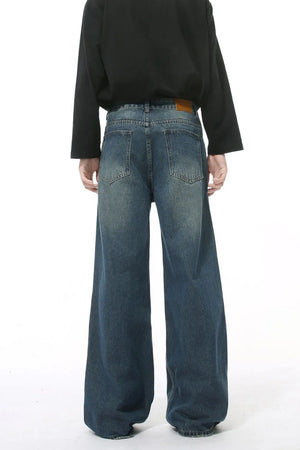 Wide leg vintage wash denim jeans in dark blue with a relaxed fit and distressed details.