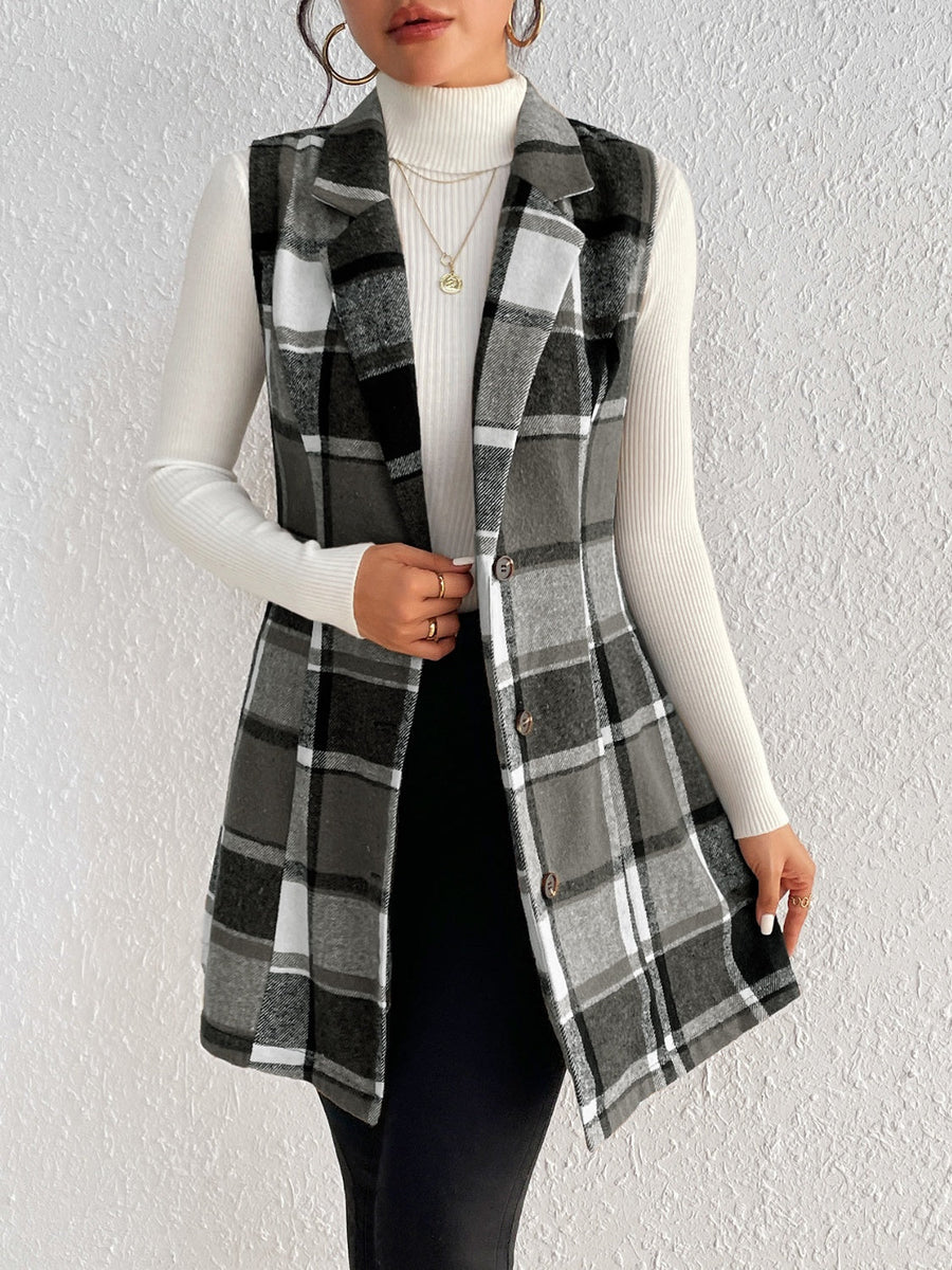 Black plaid sleeveless blazer dress with button front, styled over a white turtleneck.