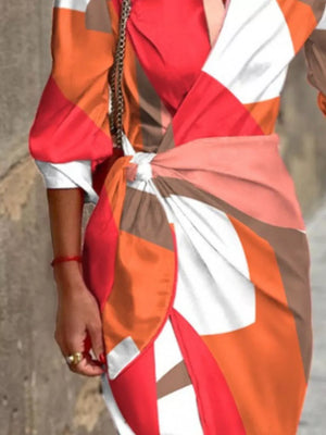 Shirt dress with abstract pattern, 3/4 sleeves, and waist tie in orange, red, and white.