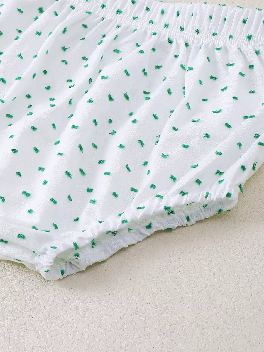 White baby shorts with green dobby dots and elastic waistband and leg openings.