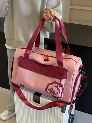 Pink Oxford cloth travel duffel bag with maroon accents and detachable strap.