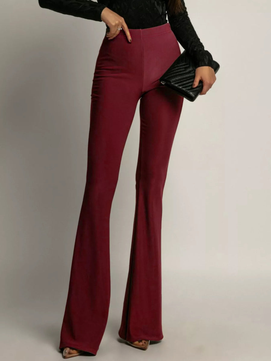 High-waisted flared trousers in red, with a fitted silhouette and wide leg opening.