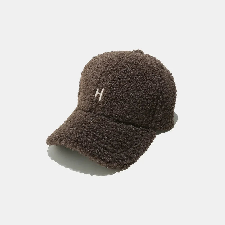 Textured sherpa baseball cap in coffee brown with embroidered white "H" detail.