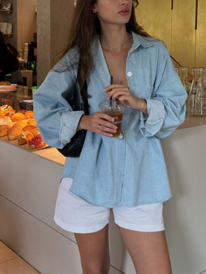 button-up shirt in light blue featuring chest pocket and oversized fit
